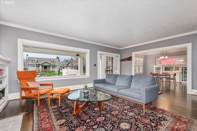 living room featuring a wealth of natural light, a textured ceiling, crown molding, and wood finished floors