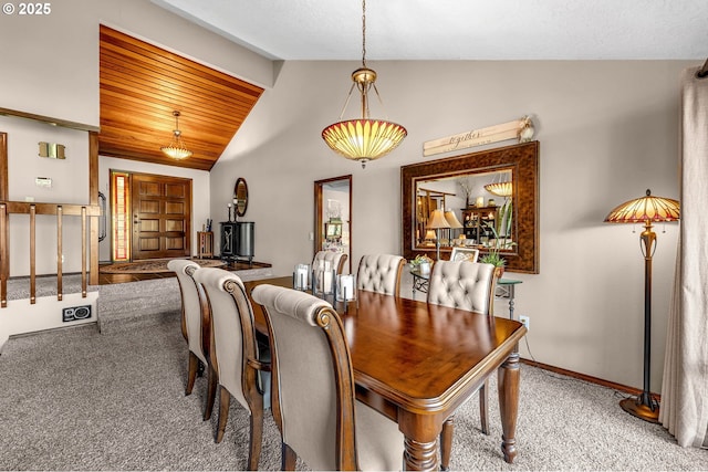 carpeted dining space with lofted ceiling and baseboards