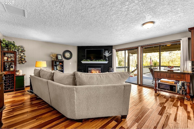 living room featuring a fireplace, hardwood / wood-style floors, and a textured ceiling