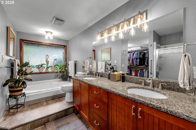 full bath featuring a stall shower, double vanity, a bath, a spacious closet, and toilet