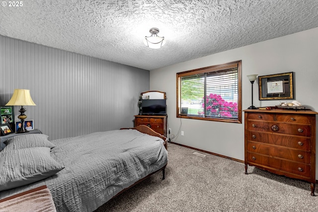 bedroom with carpet floors, baseboards, and a textured ceiling