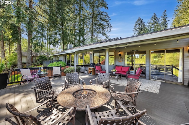 deck with an outdoor living space with a fire pit