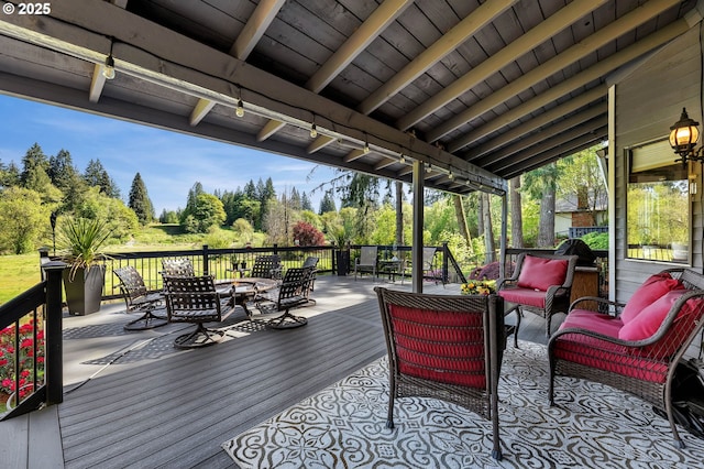 deck featuring outdoor dining space, an outdoor living space, and view of wooded area