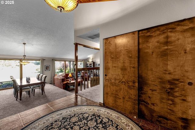 carpeted foyer with a chandelier and tile patterned floors