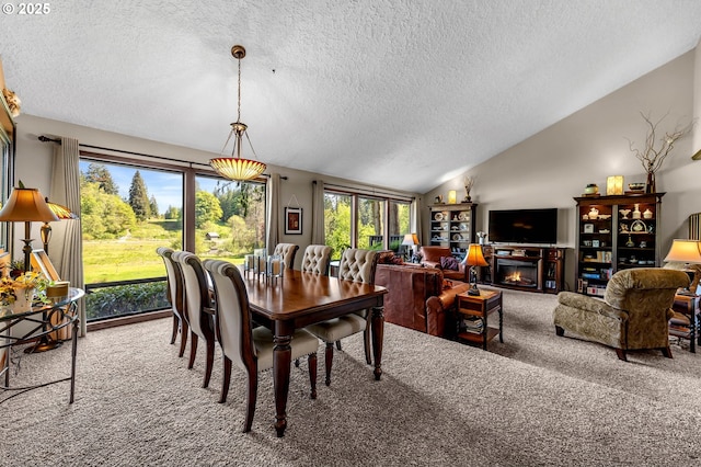 carpeted dining space with a textured ceiling, lofted ceiling, and a lit fireplace