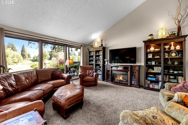 carpeted living room featuring vaulted ceiling, a textured ceiling, and a glass covered fireplace