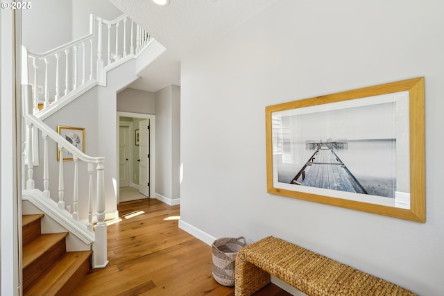 interior space with baseboards, stairway, and wood finished floors