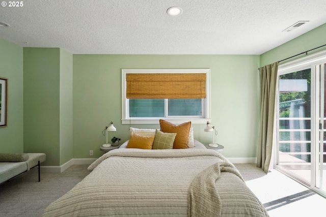 carpeted bedroom featuring a textured ceiling, visible vents, and baseboards