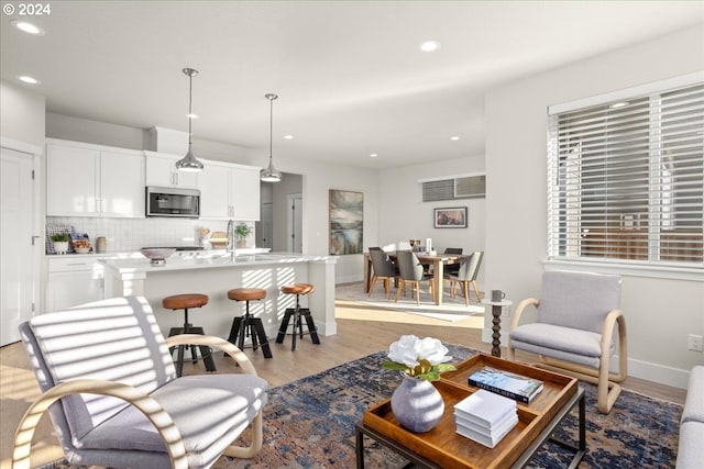 living room with sink and light hardwood / wood-style flooring