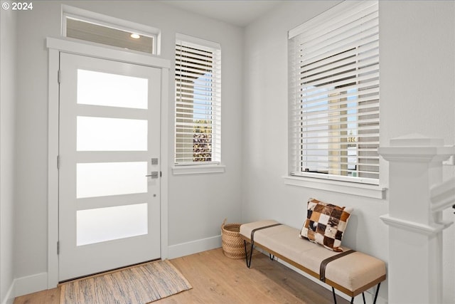 foyer entrance with wood finished floors and baseboards