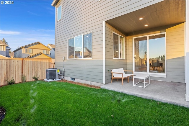 back of property featuring a yard, central AC unit, and a patio