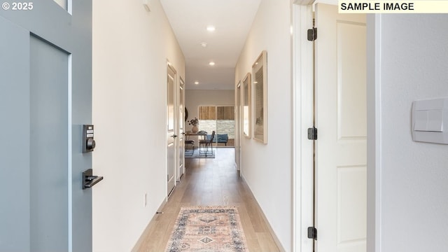 hallway with light wood-type flooring and recessed lighting