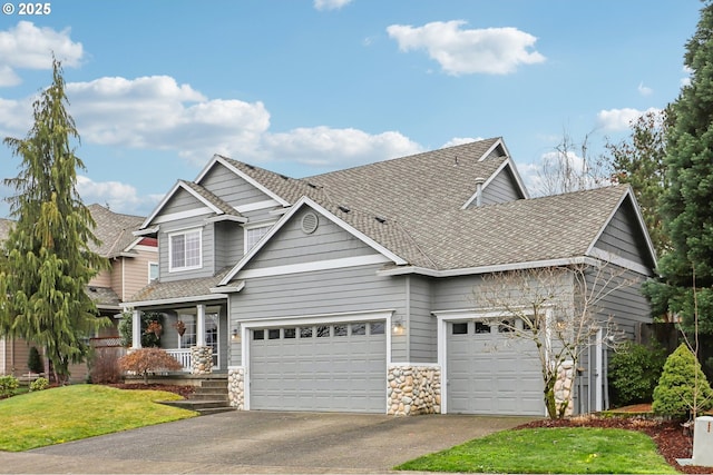 craftsman-style home featuring a front yard, a garage, and covered porch