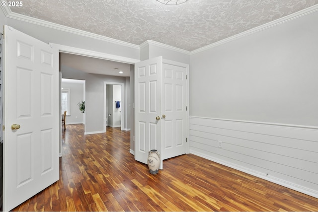 spare room with dark hardwood / wood-style flooring, a textured ceiling, and crown molding