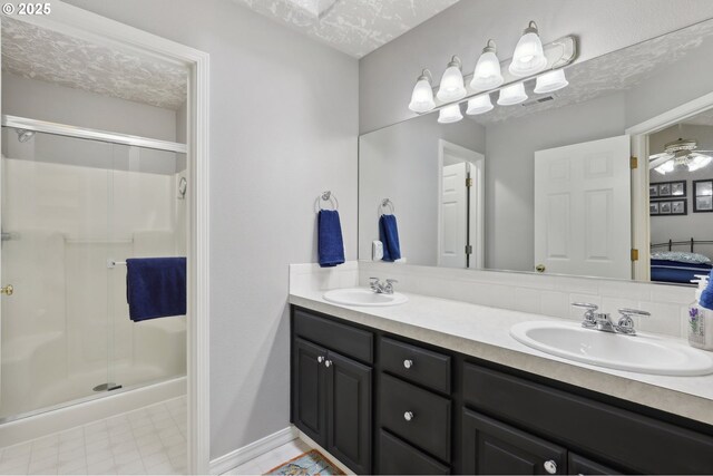 bathroom with a textured ceiling, a shower with door, and vanity