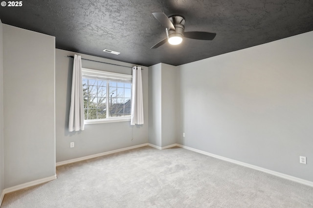 carpeted empty room featuring a textured ceiling and ceiling fan