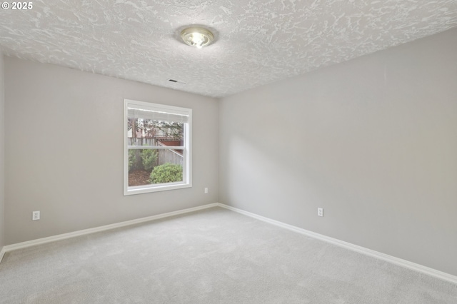 unfurnished room with a textured ceiling and carpet flooring