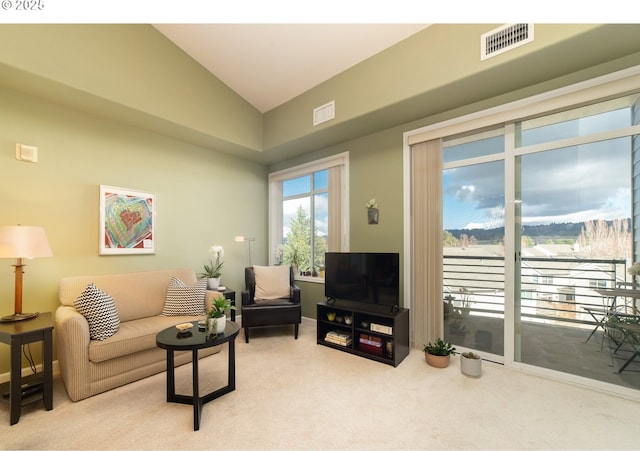 living room with vaulted ceiling, carpet, and visible vents