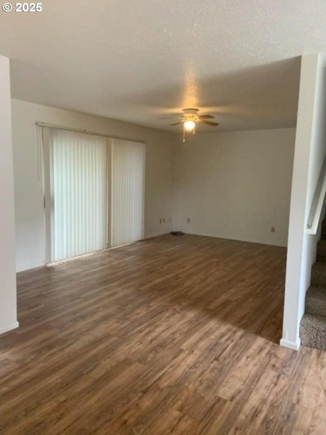 interior space with stairway, a ceiling fan, and wood finished floors
