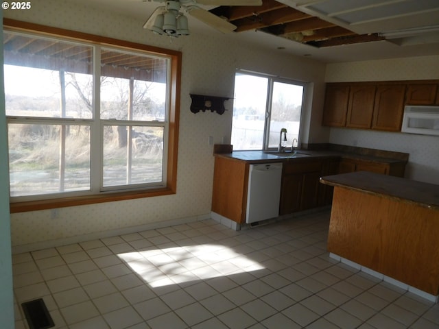 kitchen featuring light tile patterned flooring, white appliances, ceiling fan, and sink