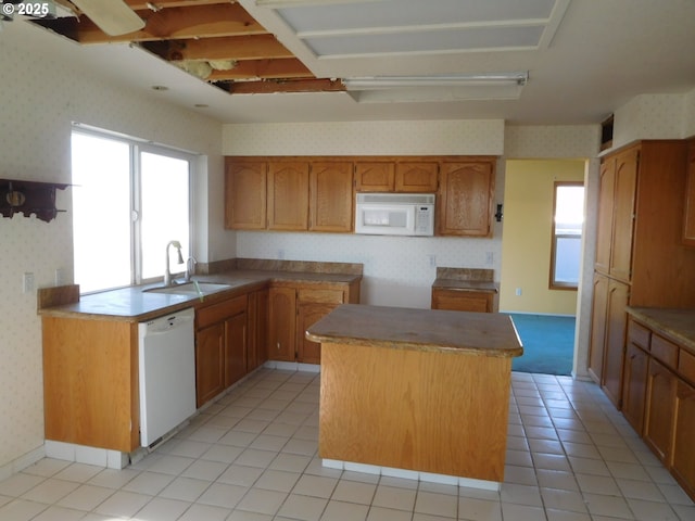 kitchen featuring white appliances, sink, a kitchen island, and light tile patterned floors