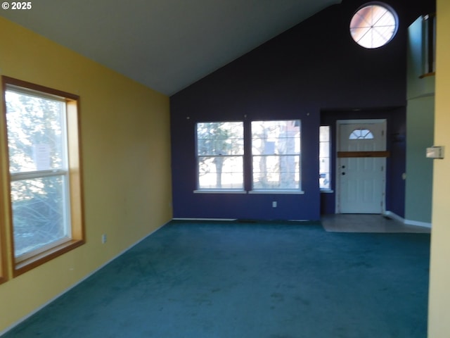 interior space featuring lofted ceiling, a wealth of natural light, and dark carpet