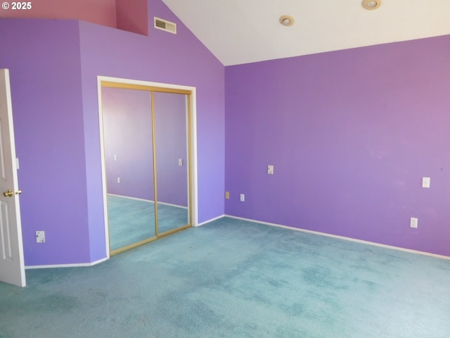 unfurnished bedroom featuring carpet floors, vaulted ceiling, and a closet