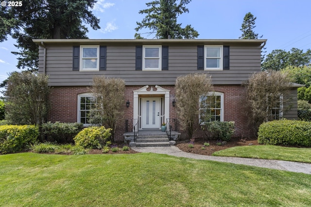 5707 SW Menefee Dr, Portland, OR 97239 - colonial home featuring a front yard and brick siding