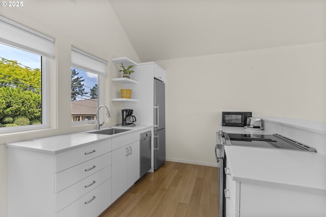 5707 SW Menefee Dr, Portland, OR 97239 - kitchen featuring stainless steel appliances, open shelves, light wood-type flooring, lofted ceiling, and white cabinets