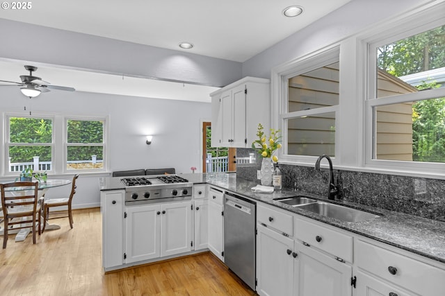 5707 SW Menefee Dr, Portland, OR 97239 - kitchen with stainless steel appliances, a peninsula, healthy amount of natural light, light wood-type flooring, and recessed lighting