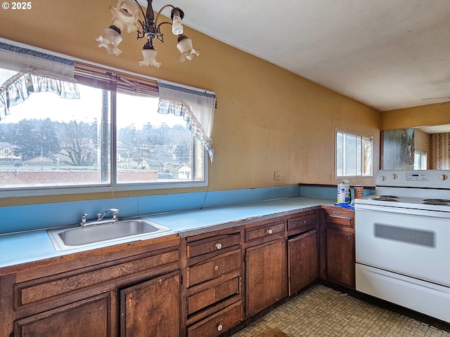 kitchen featuring sink, a chandelier, and white range with electric cooktop