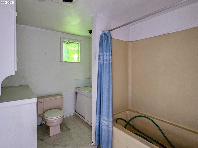 bathroom featuring shower / bath combination with curtain and toilet