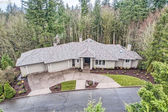 single story home featuring a garage and a front lawn