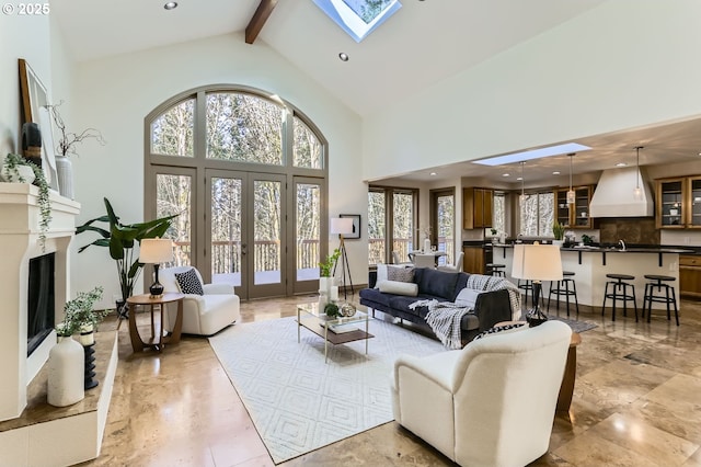 living room featuring french doors, plenty of natural light, beam ceiling, and a skylight