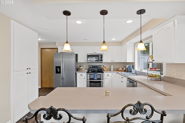 4931 NE Mink Ct, Salem, OR 97305 - kitchen with appliances with stainless steel finishes, a kitchen bar, light countertops, a peninsula, and recessed lighting