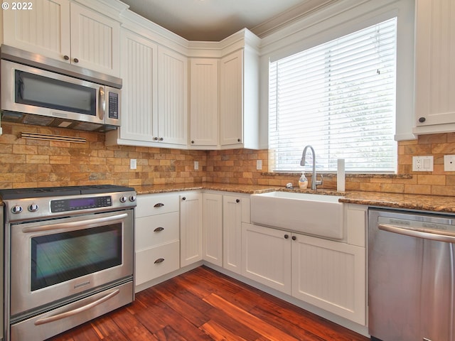 kitchen with sink, backsplash, stainless steel appliances, white cabinets, and stone countertops