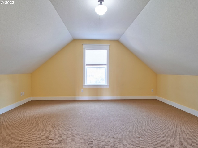 bonus room featuring lofted ceiling and carpet flooring