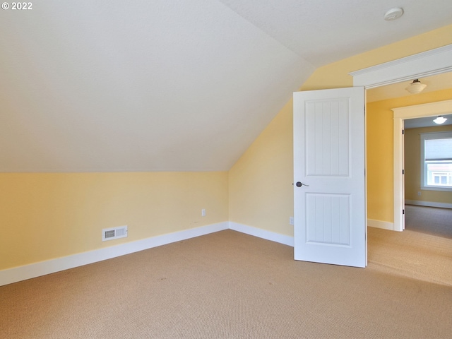 bonus room with lofted ceiling and carpet