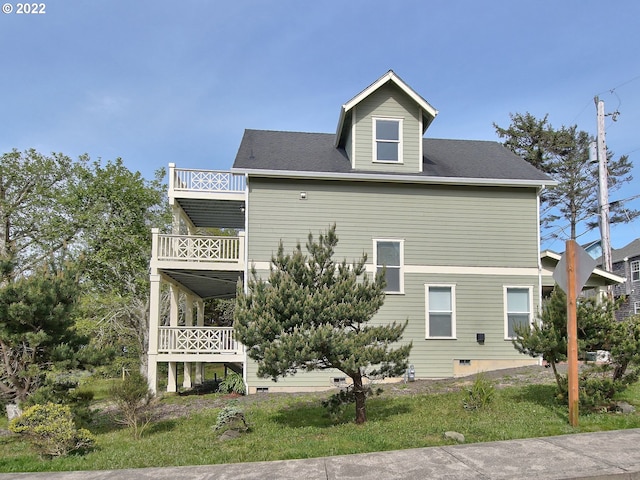 exterior space with a balcony and a lawn