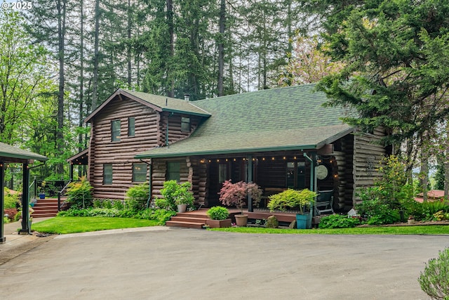 log home with covered porch and log siding