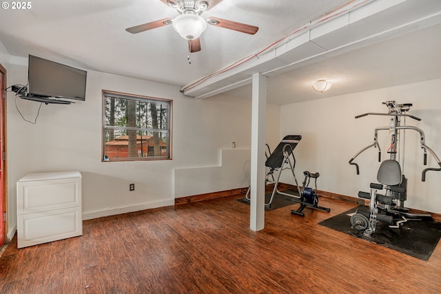 exercise room featuring a ceiling fan, baseboards, and wood finished floors