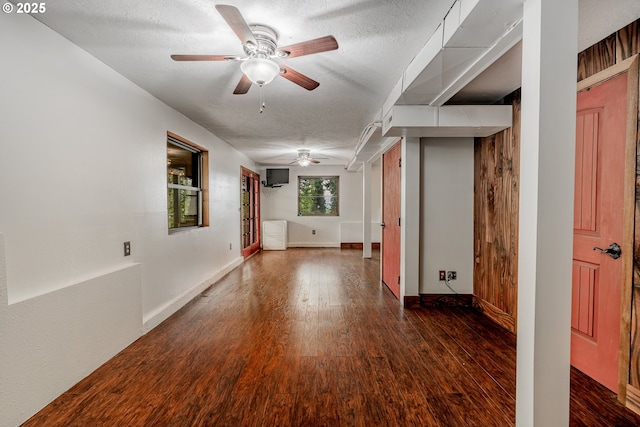 unfurnished room with baseboards, a ceiling fan, a textured ceiling, and wood finished floors