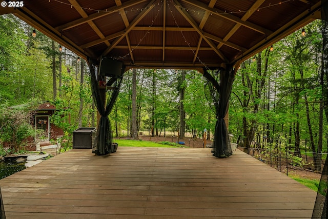 wooden deck with a gazebo and a wooded view