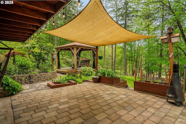 view of patio featuring a gazebo and a vegetable garden