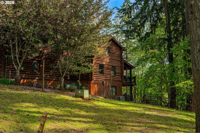 view of side of home with a lawn, log siding, and a deck