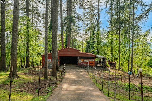 view of community featuring an outbuilding, a detached garage, and concrete driveway