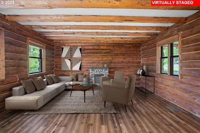 living room with log walls, beamed ceiling, wood finished floors, and visible vents