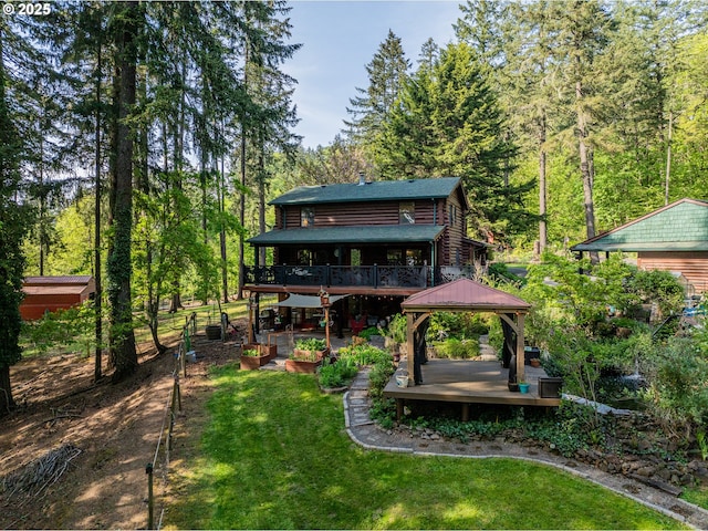 view of yard with a view of trees, a wooden deck, and a gazebo