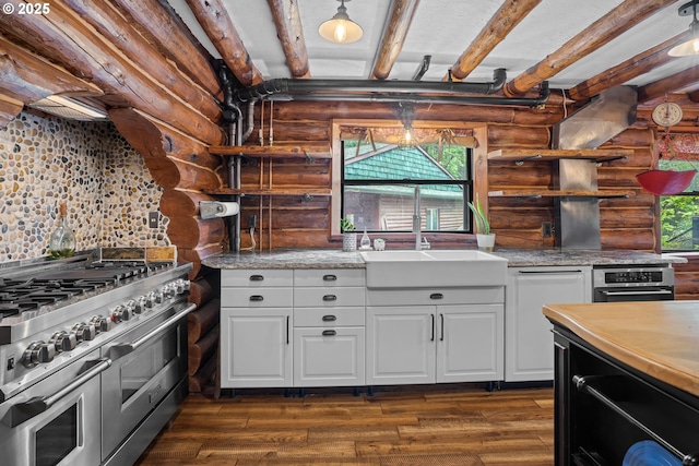 kitchen featuring range with two ovens, beam ceiling, a sink, and log walls