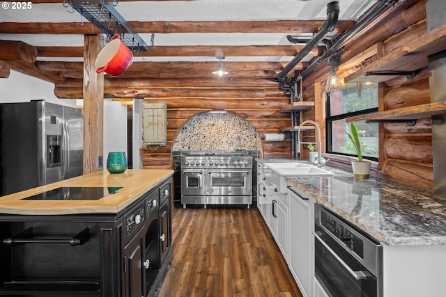 kitchen with dark wood-style flooring, open shelves, a sink, dark cabinets, and log walls
